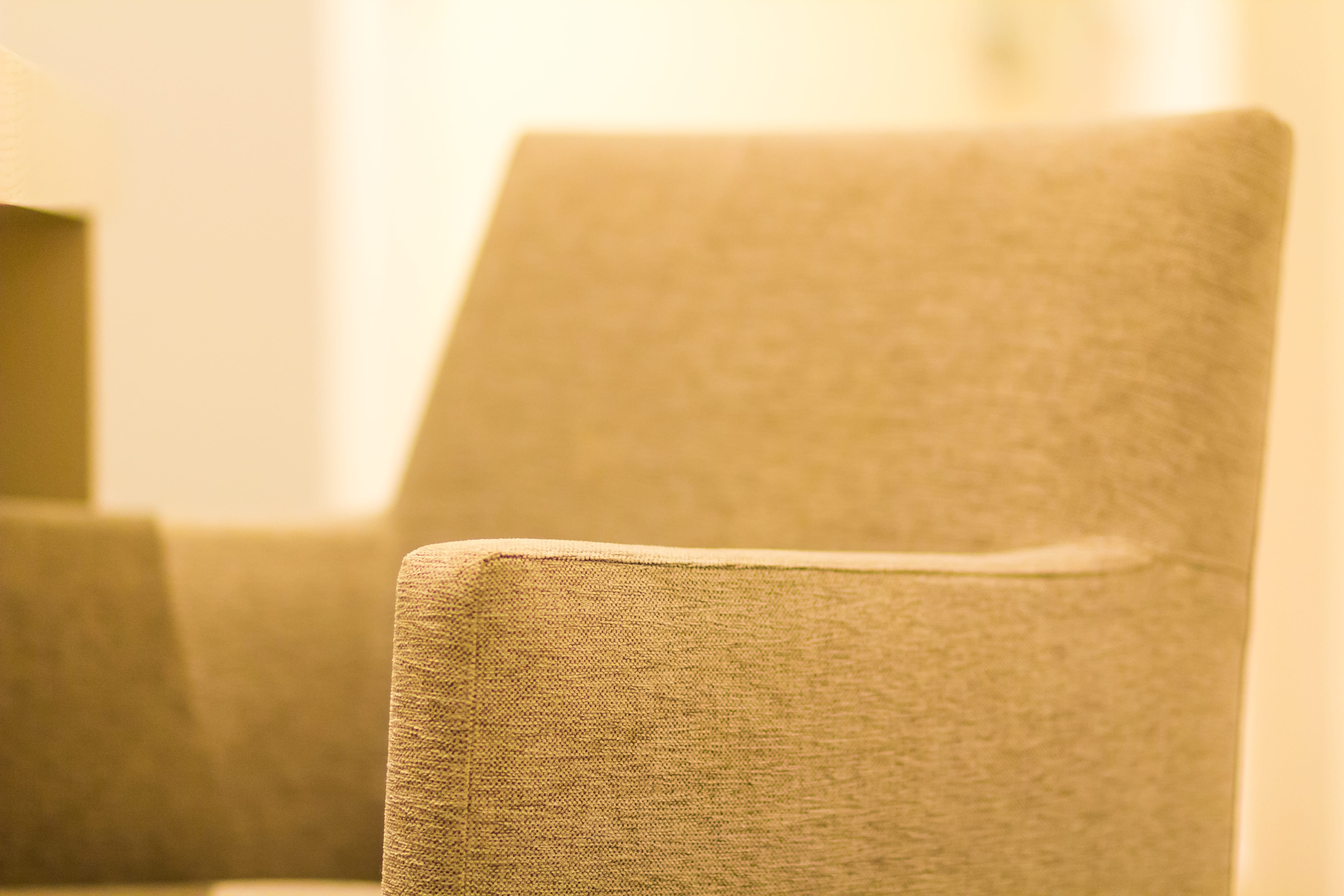 a tan couch with a white pillow