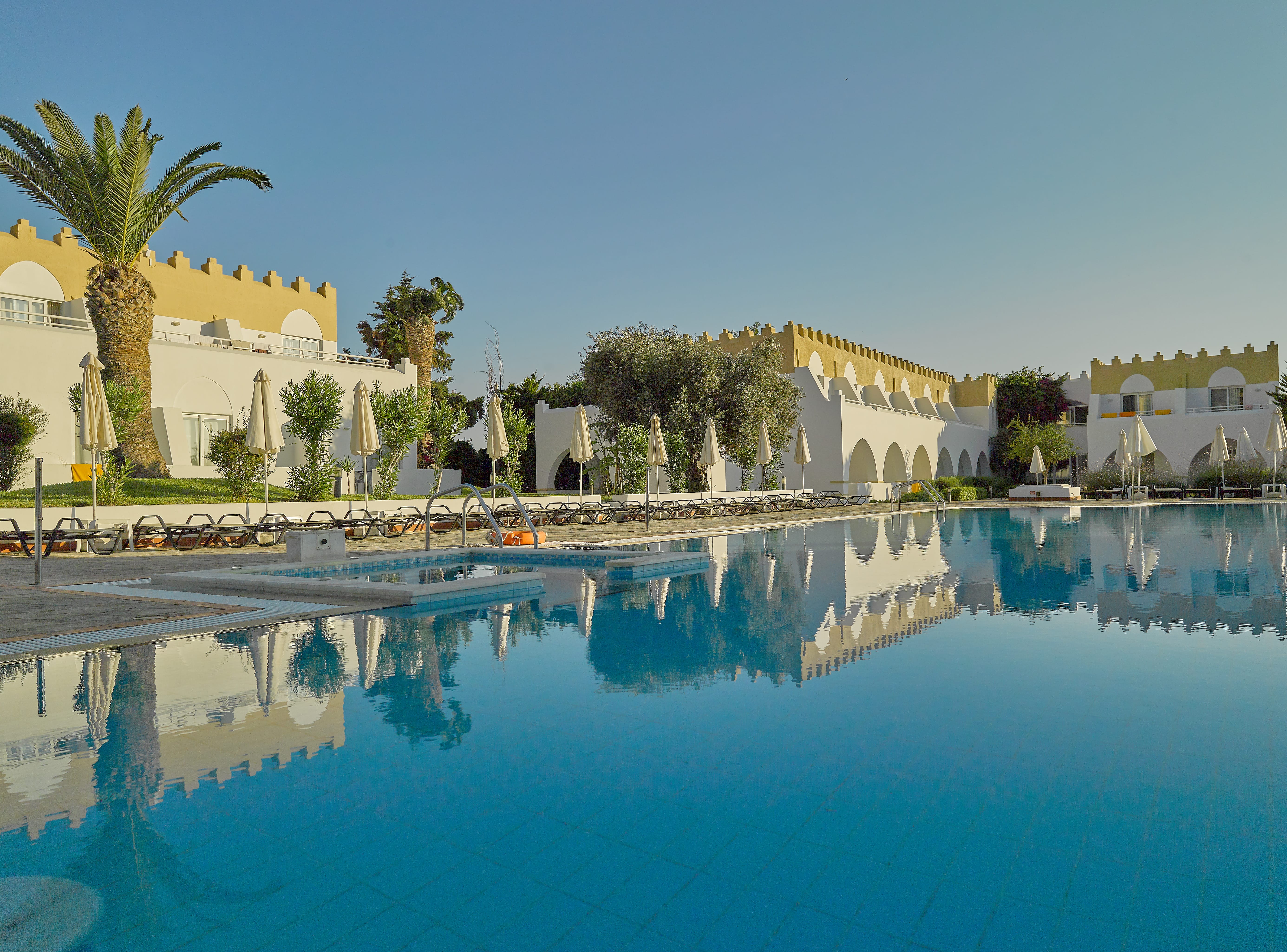 a pool with palm trees and buildings