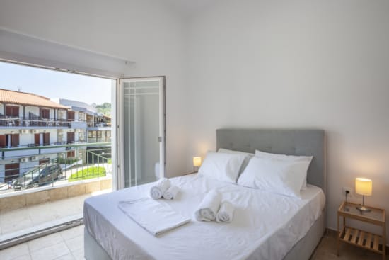 a bed with white sheets and towels