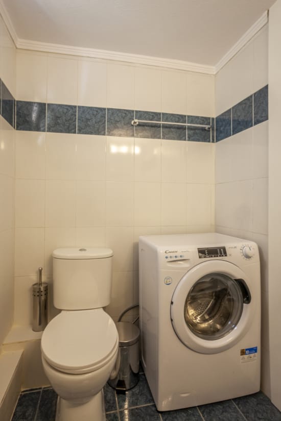 a toilet and a washer in a bathroom
