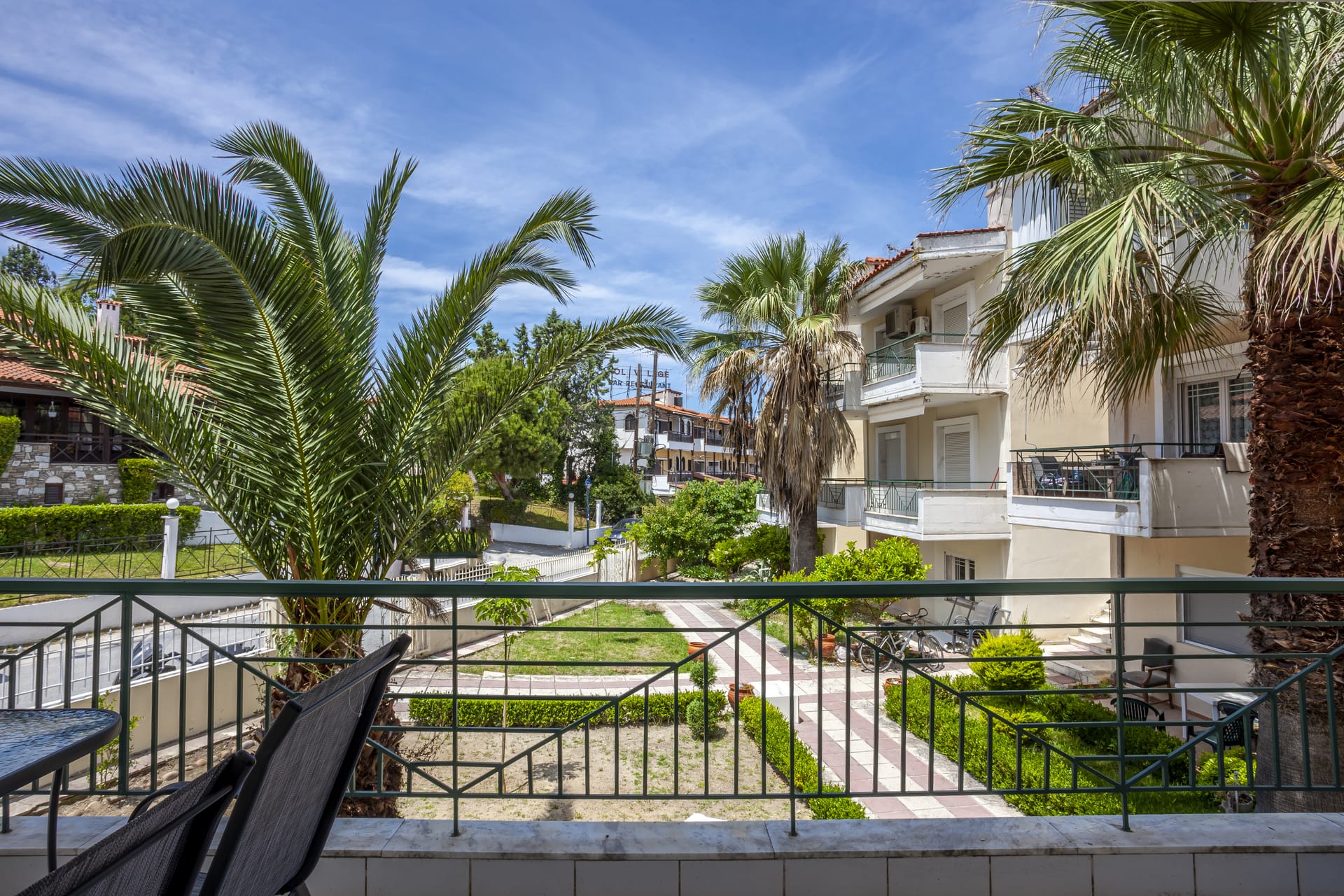 a building with palm trees and a fence around it