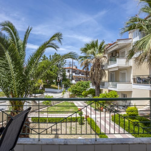 a building with palm trees and a fence around it