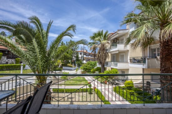 a building with palm trees and a fence around it