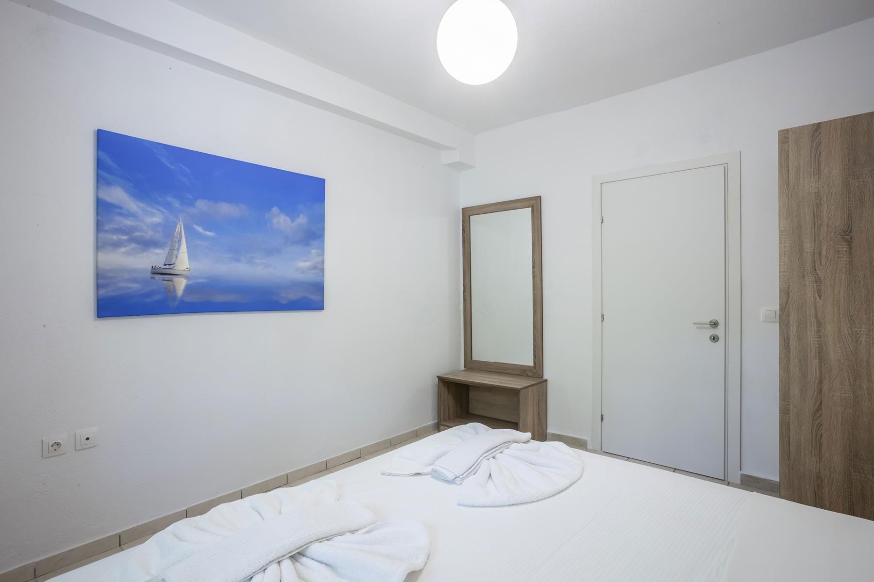 a room with a bed and a painting on the wall