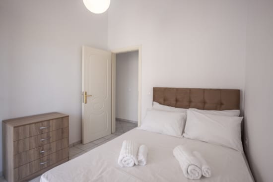 a bed with white sheets and pillows