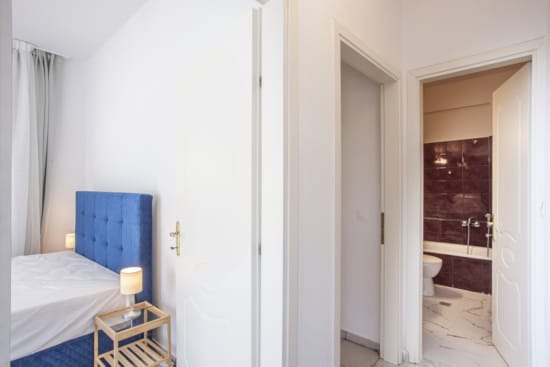 a bathroom with a bed and a small bed