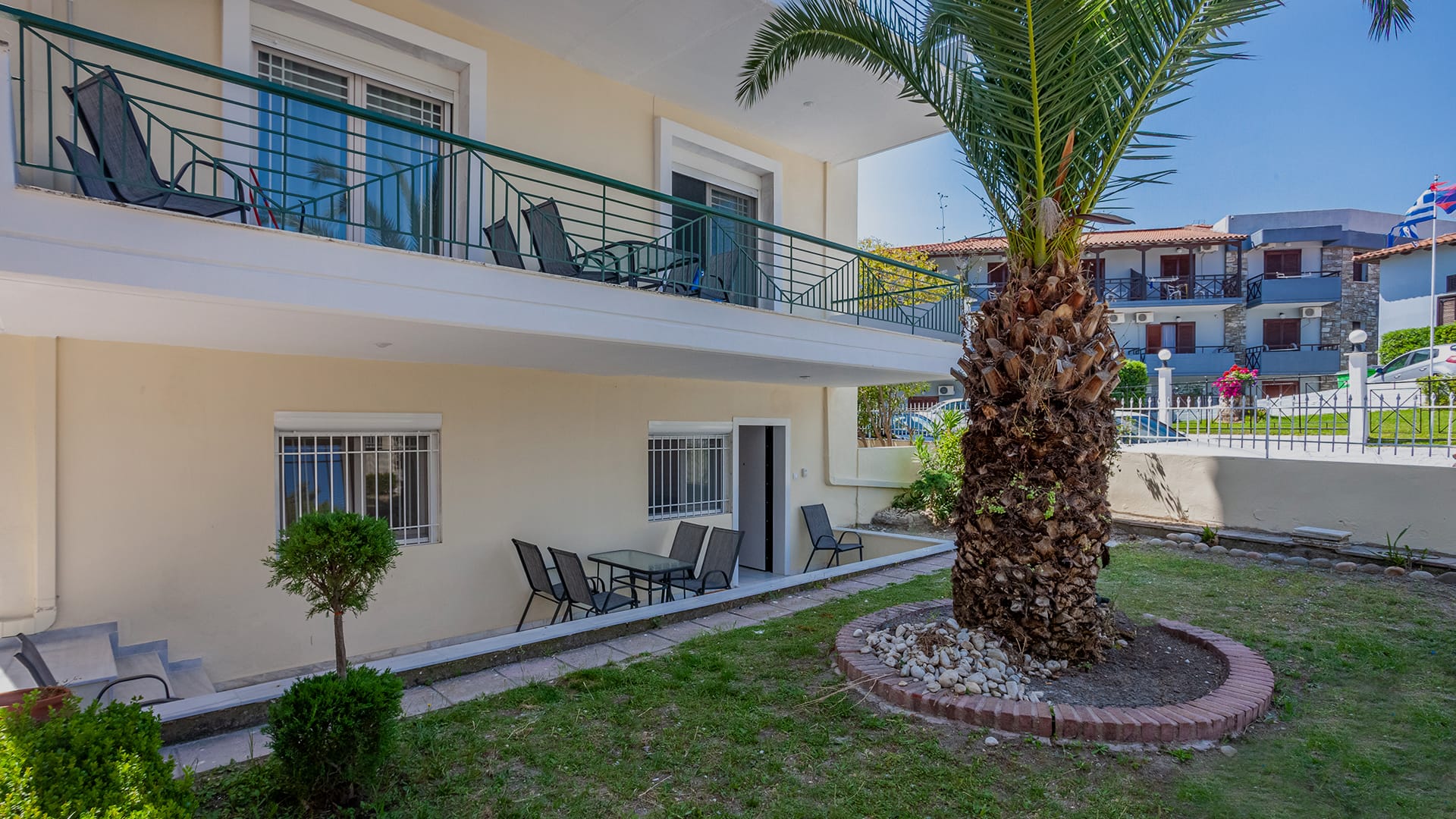 a courtyard with palm trees and a building in the background