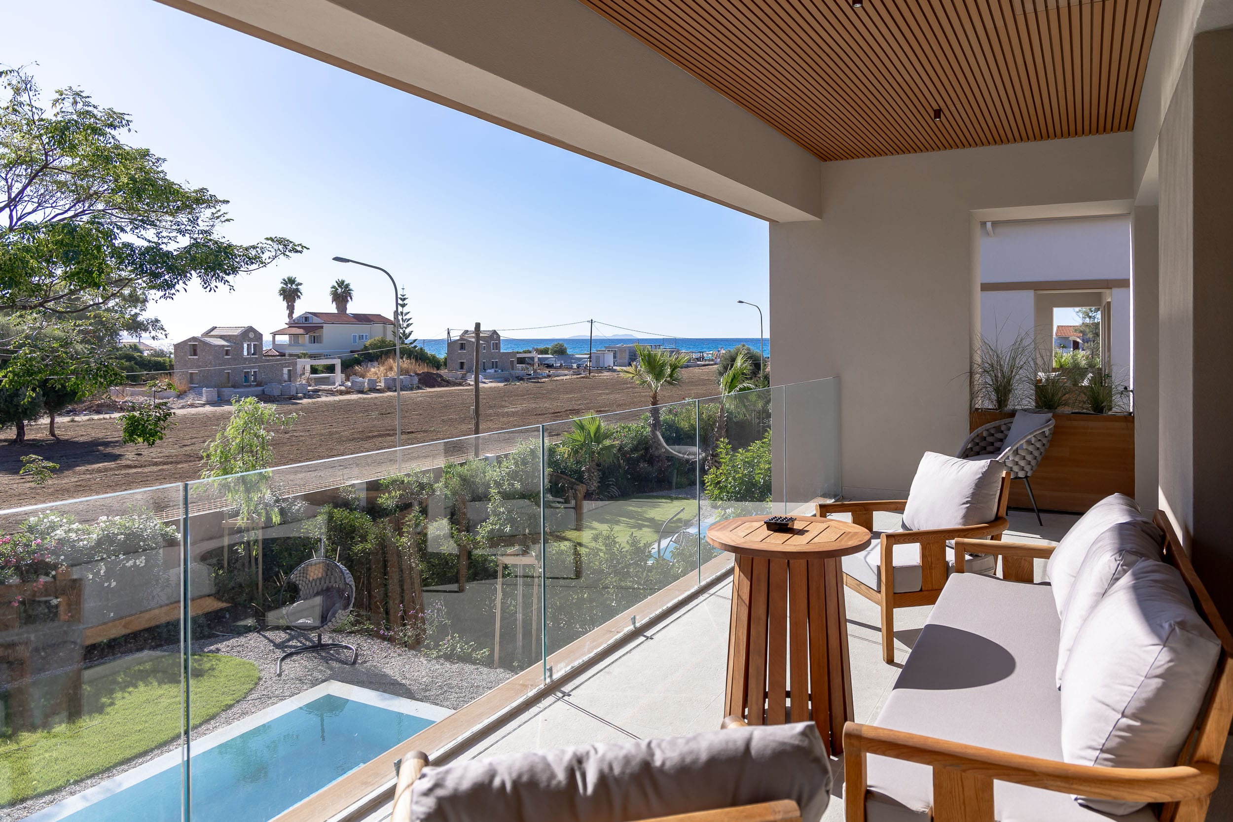 a pool and lounge chairs in a room with a large window