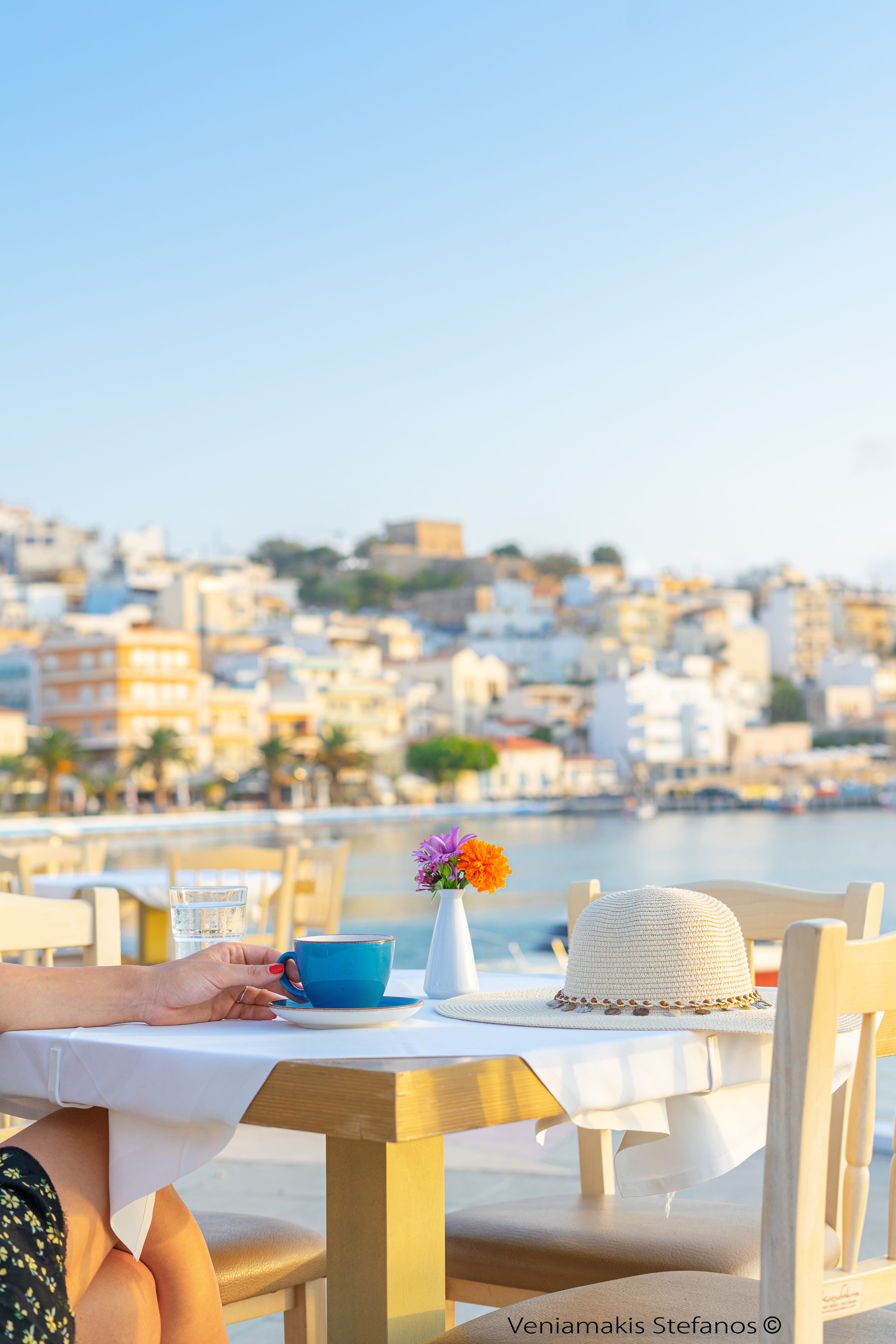 a person sitting at a table with a vase of flowers