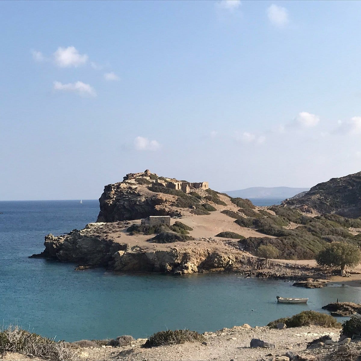 a rocky beach with a body of water in the background