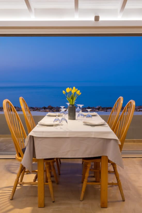 a table with chairs and a vase of flowers on it