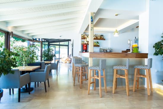 a room with a table chairs and a large window