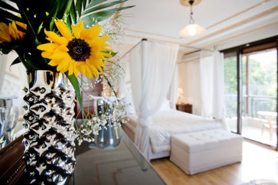 a room with a bed and a vase of flowers