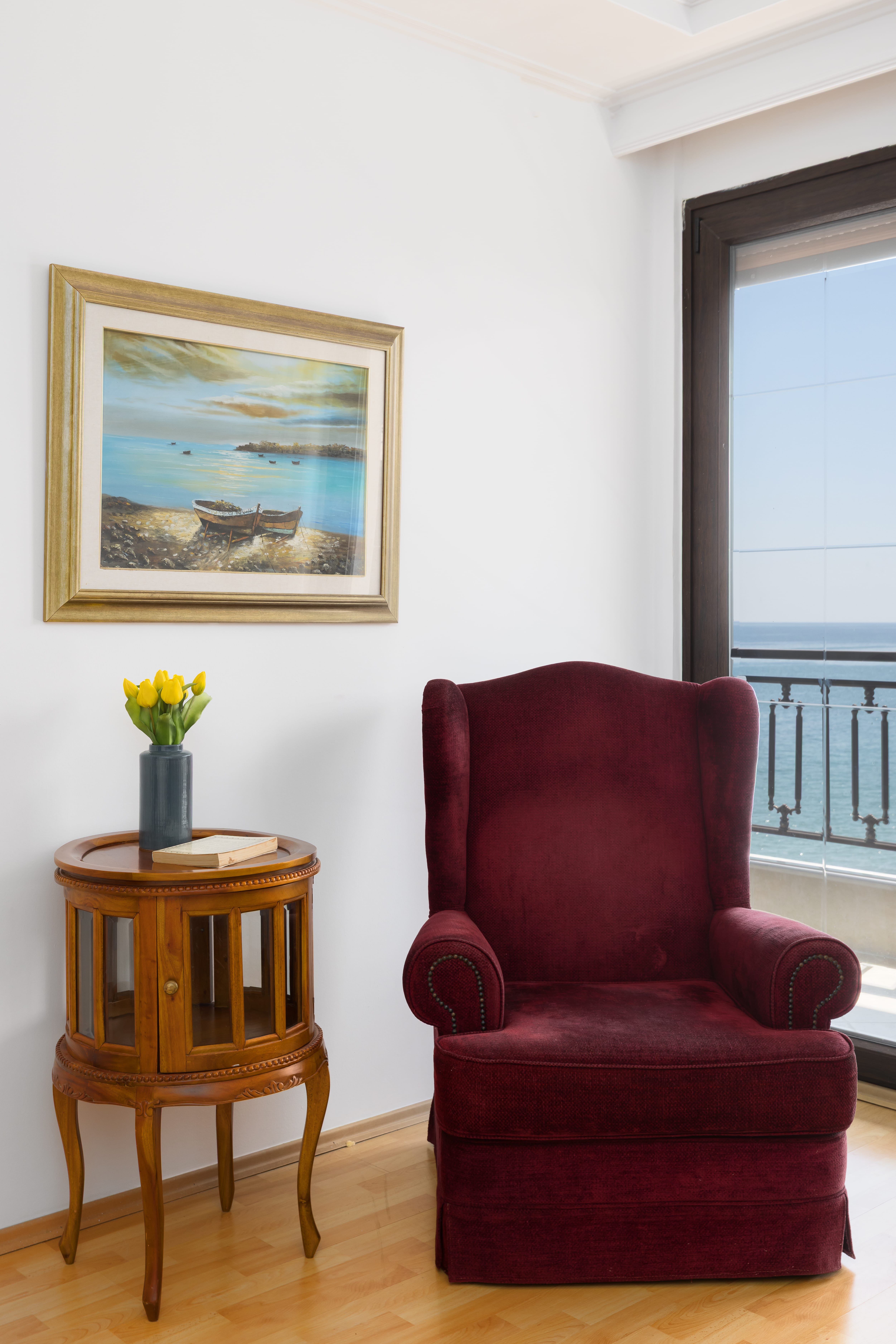a red chair next to a painting