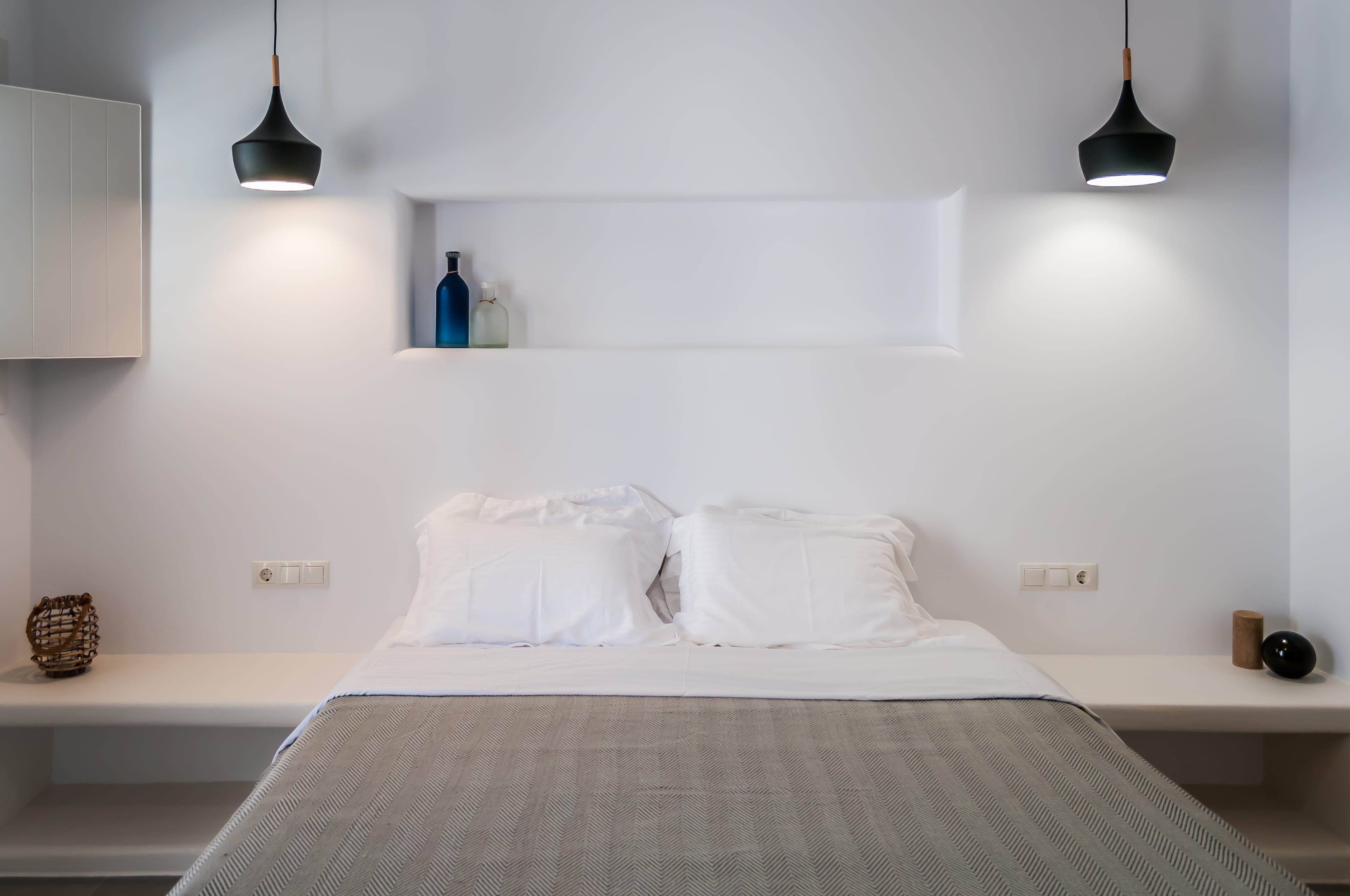 a bed with white sheets and pillows