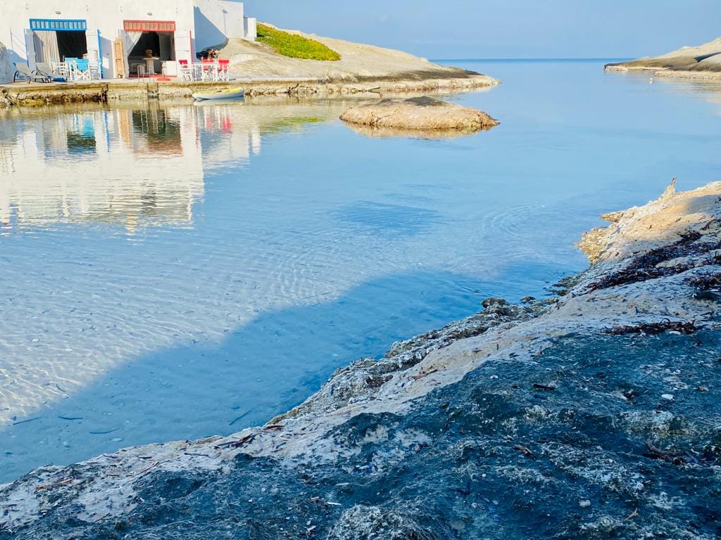 a body of water with a building in the background