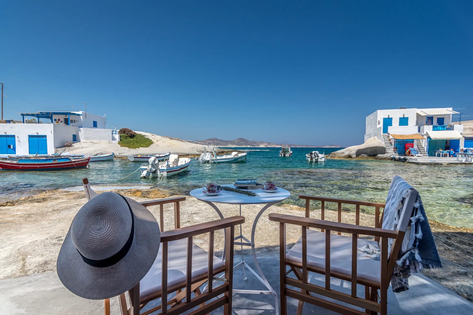 a hat on a deck overlooking a bay with boats