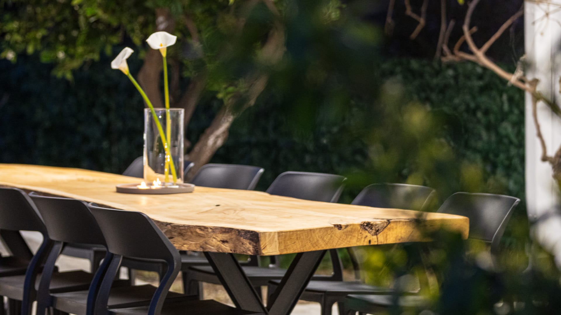 a table with chairs and a vase of flowers on it