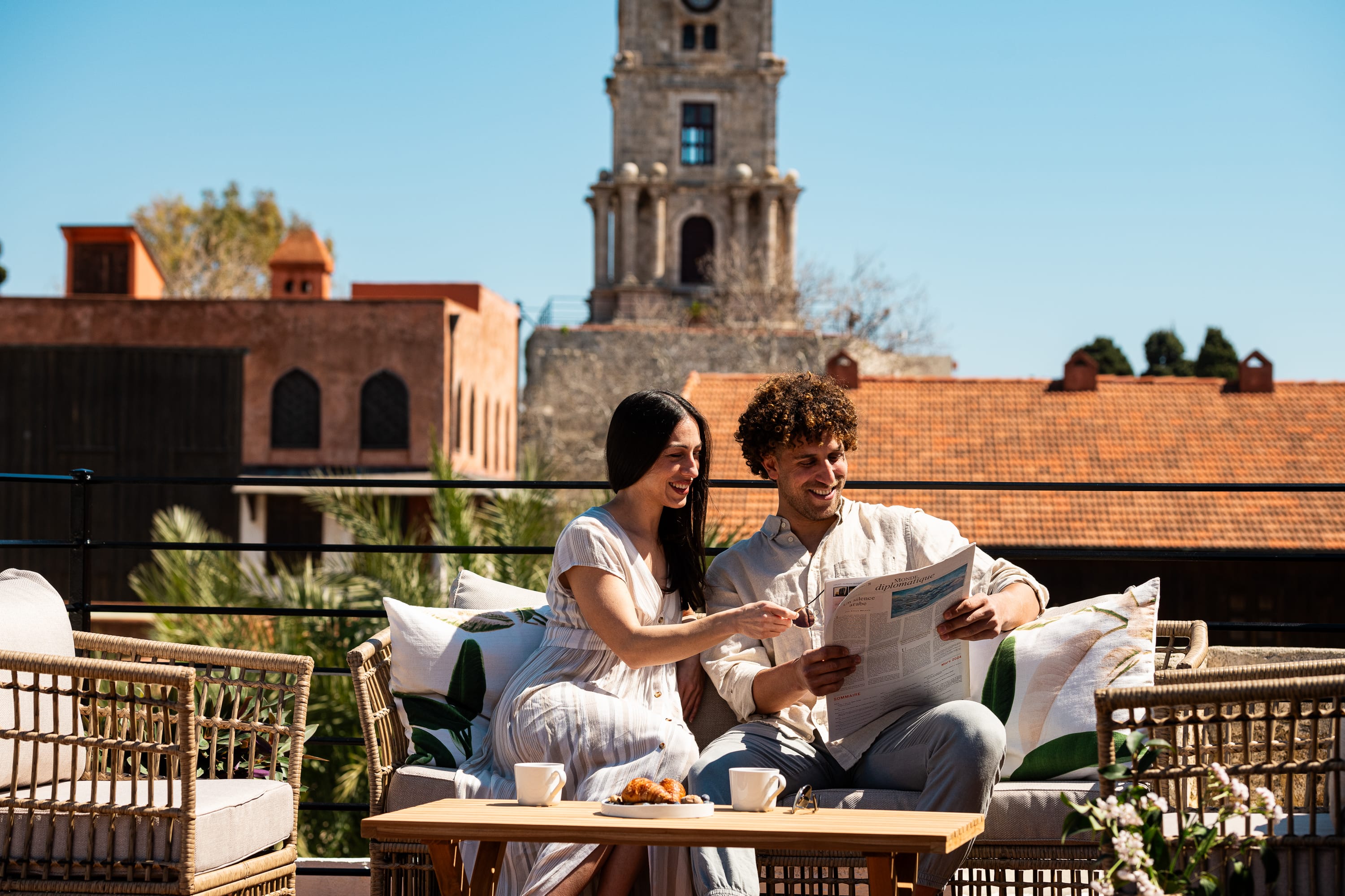 a man and woman sitting at a table with a laptop