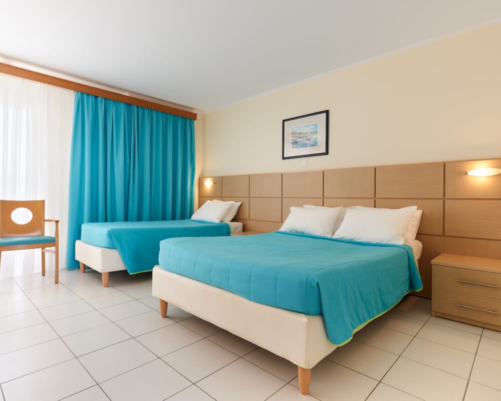 a room with a bed and chairs