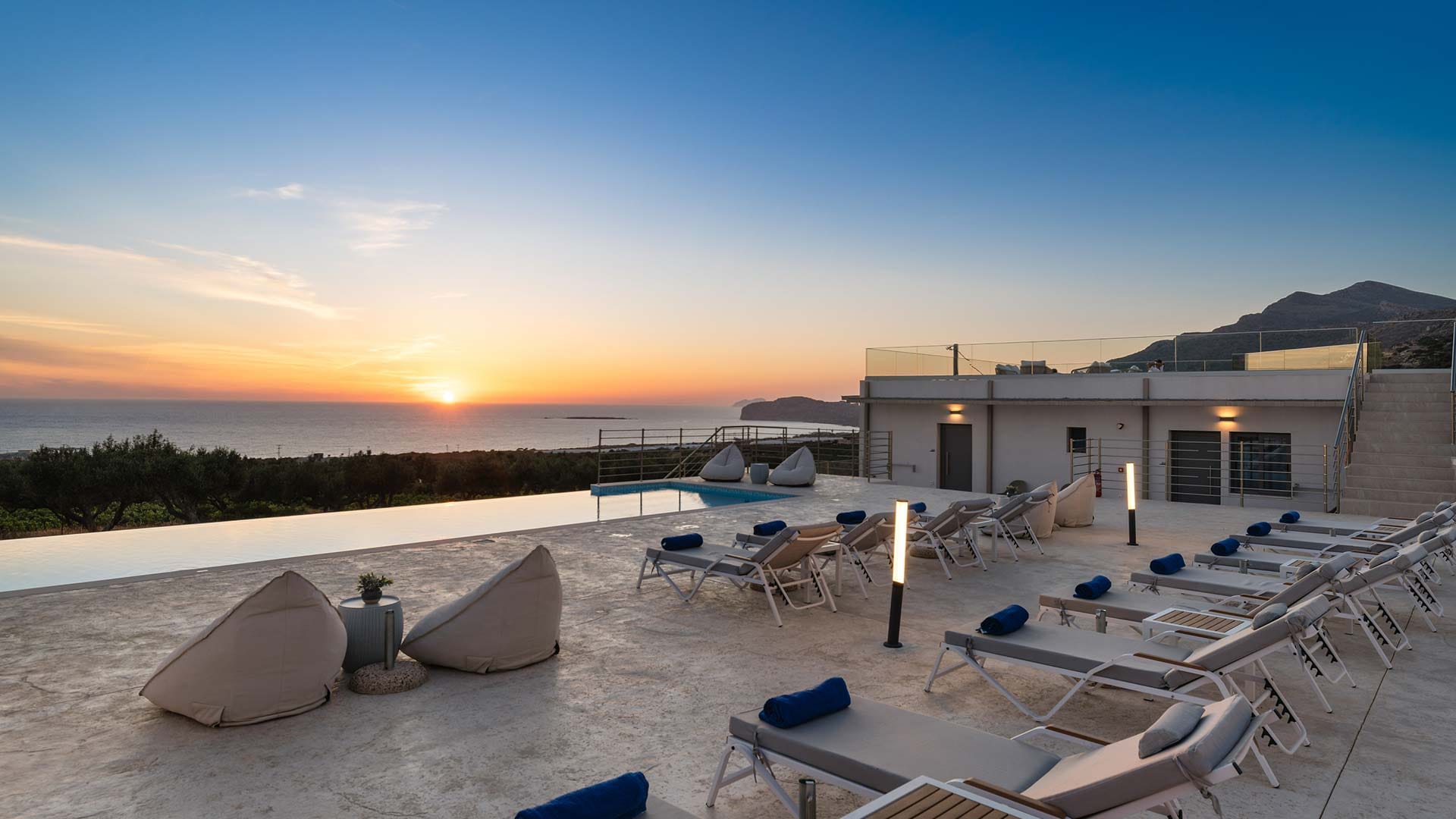 a building with a pool and chairs in the front