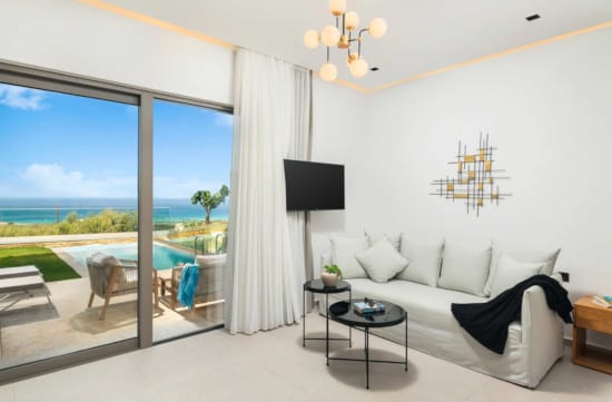 a room with a large window and a couch and a table with a lamp and a view of