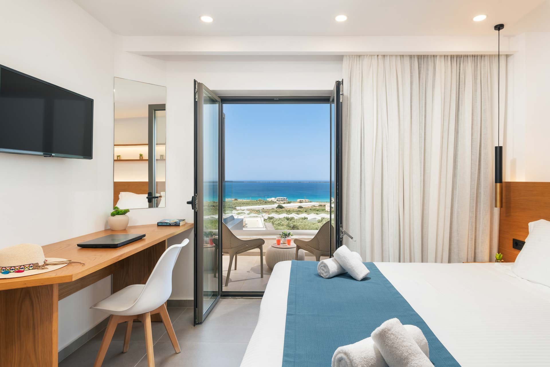 a room with a bed and a table with a tv and a window