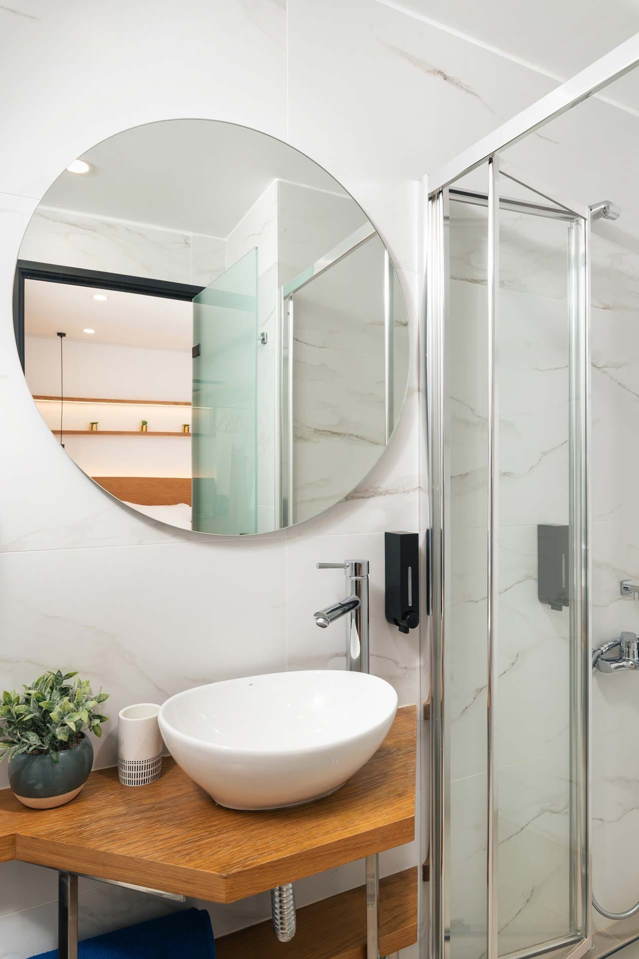 a bathroom with a round mirror
