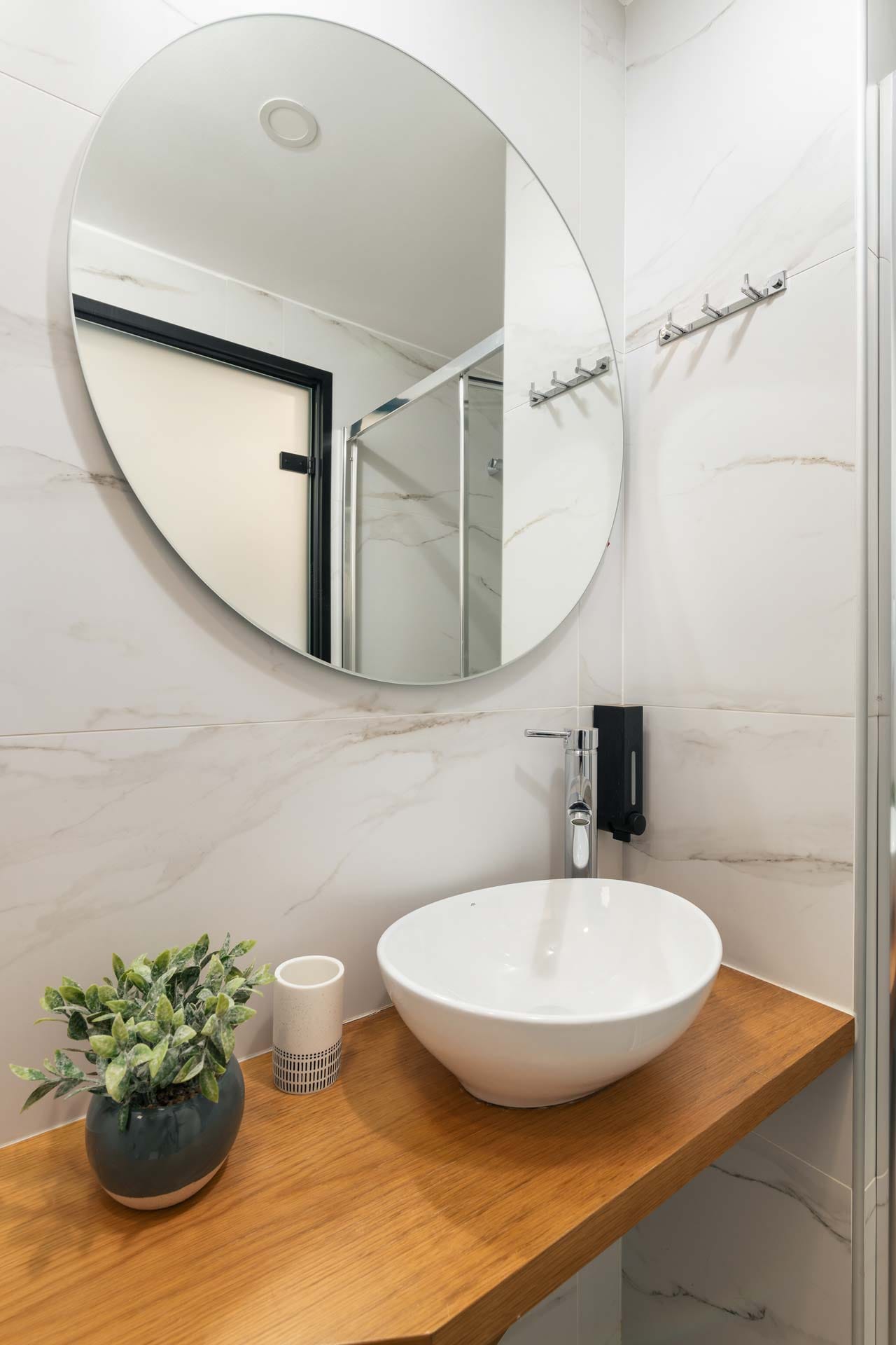 a bathroom with a round mirror