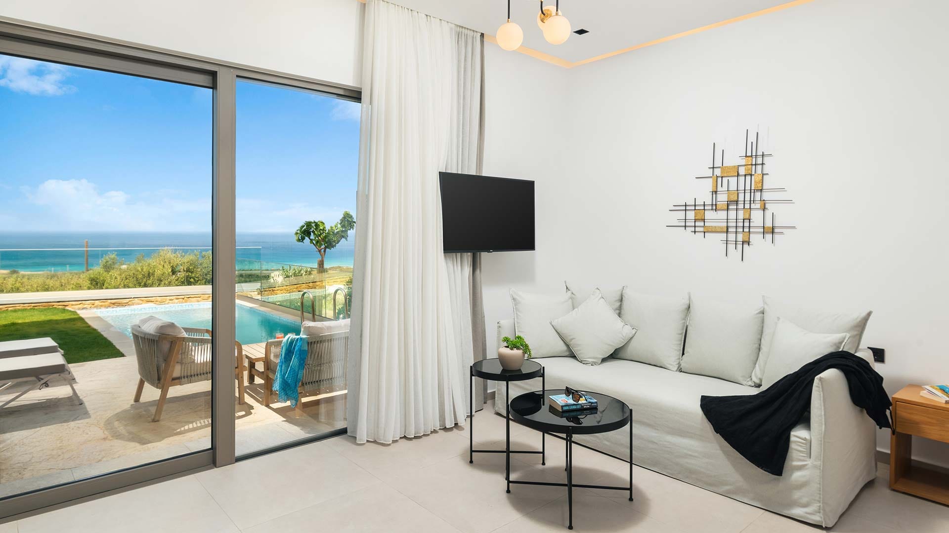 a room with a large window and a couch and a table with a tv and a table with