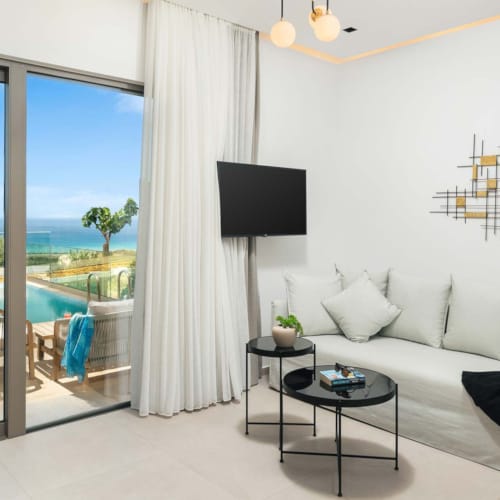 a room with a large window and a couch and a table with a tv and a table with