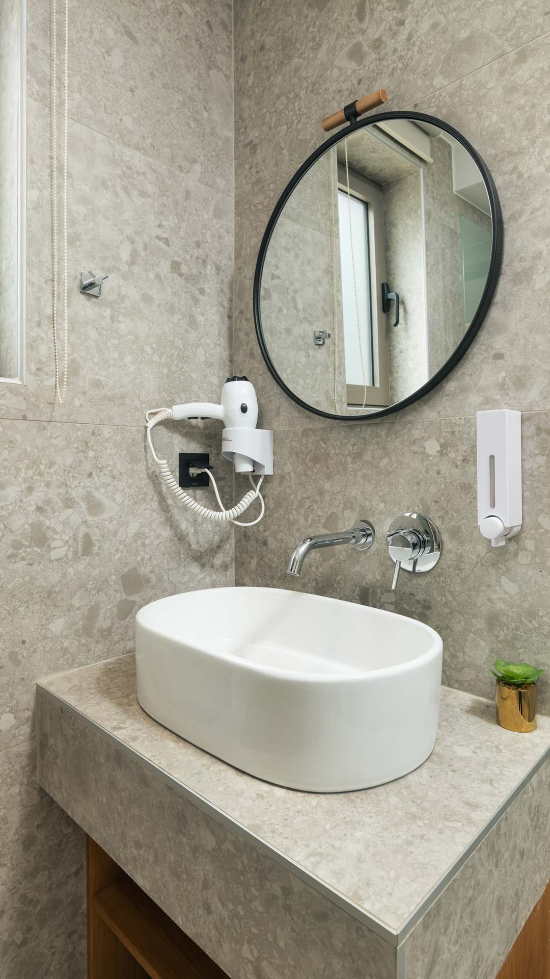 a bathroom with a round mirror