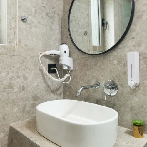 a bathroom with a round mirror