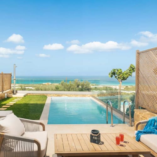 a pool and chairs by a deck