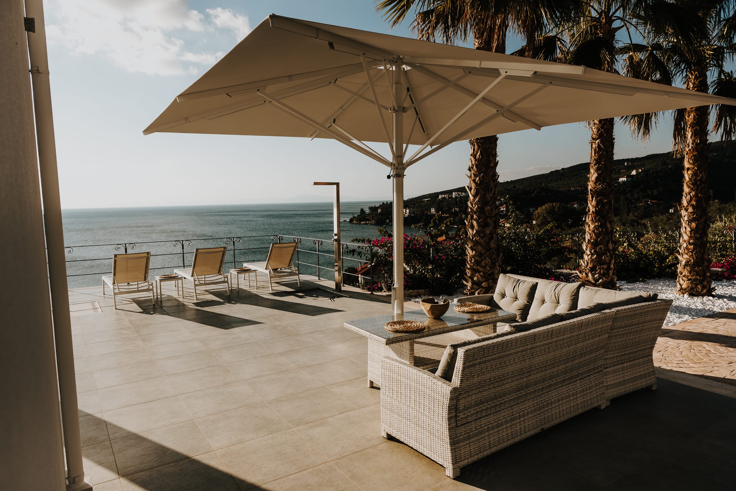 a lounge area with chairs and umbrellas by the beach