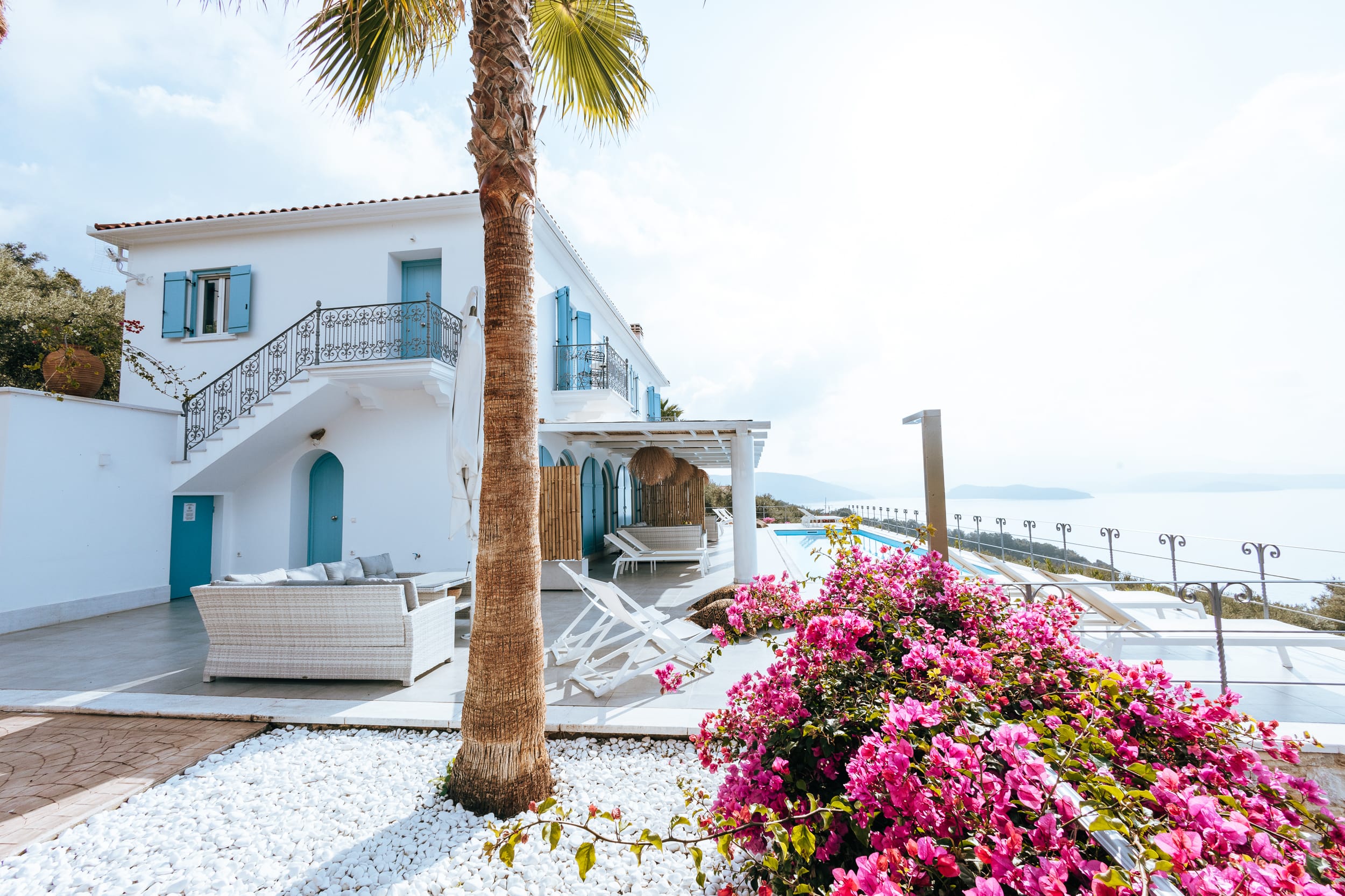 a house with a palm tree and a beach in the background