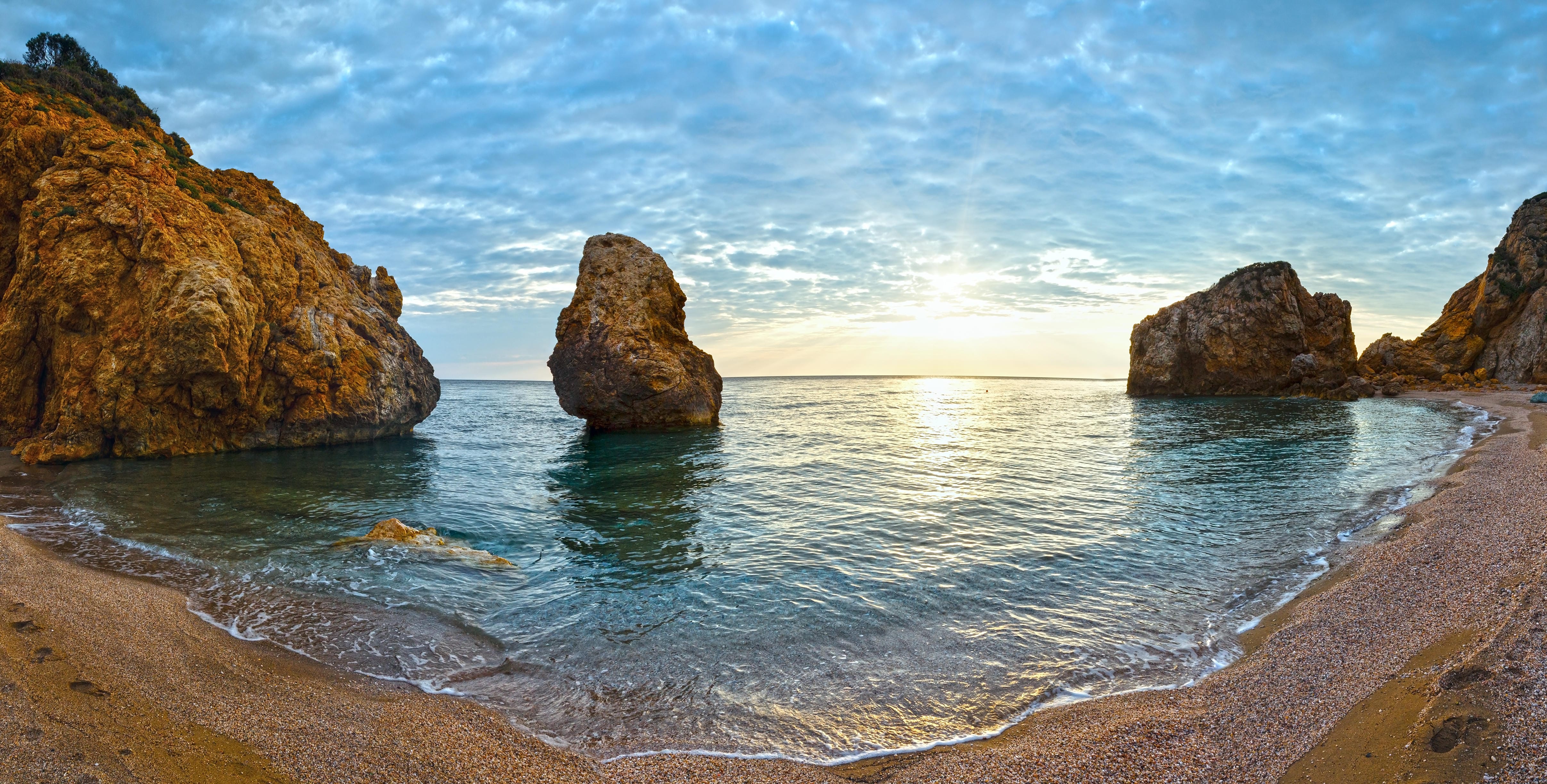 a body of water with rocks and a beach