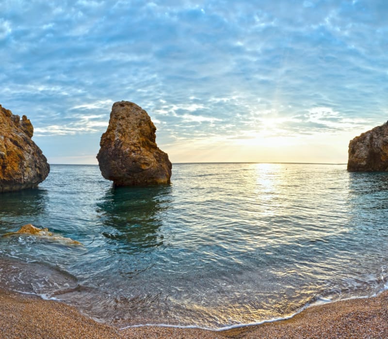 a body of water with rocks and a beach