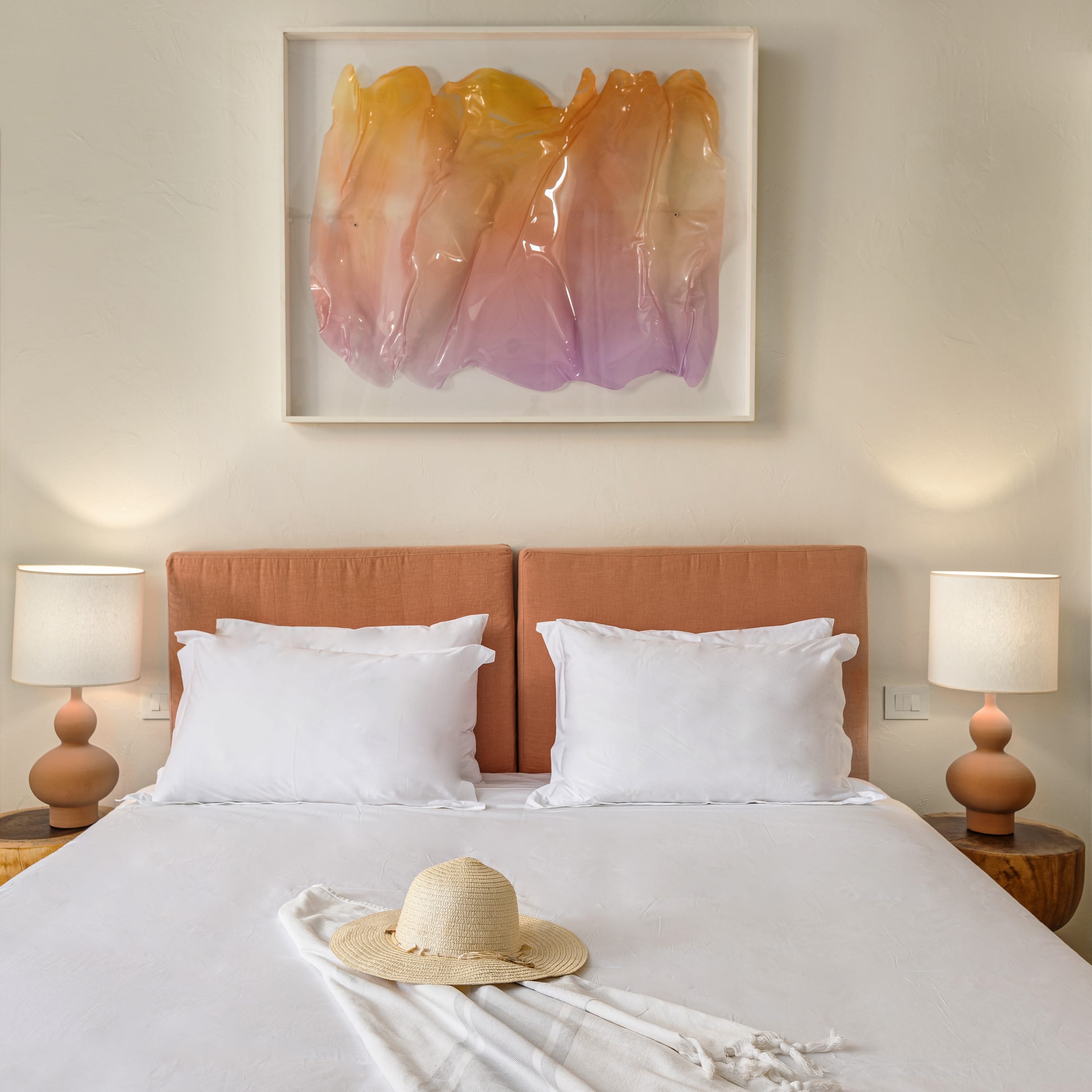 a bed with a painting on the wall