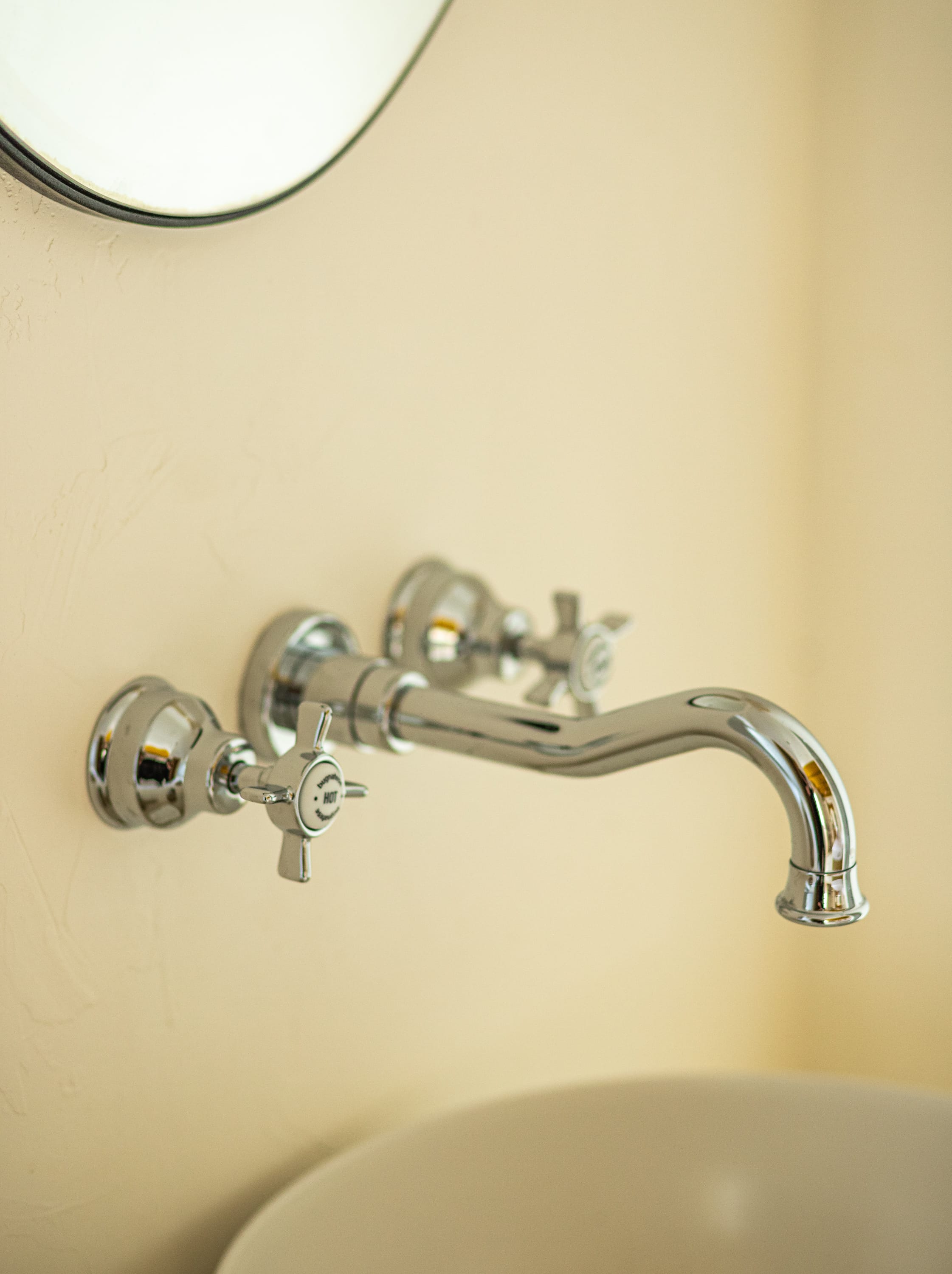 a silver faucet on a white wall