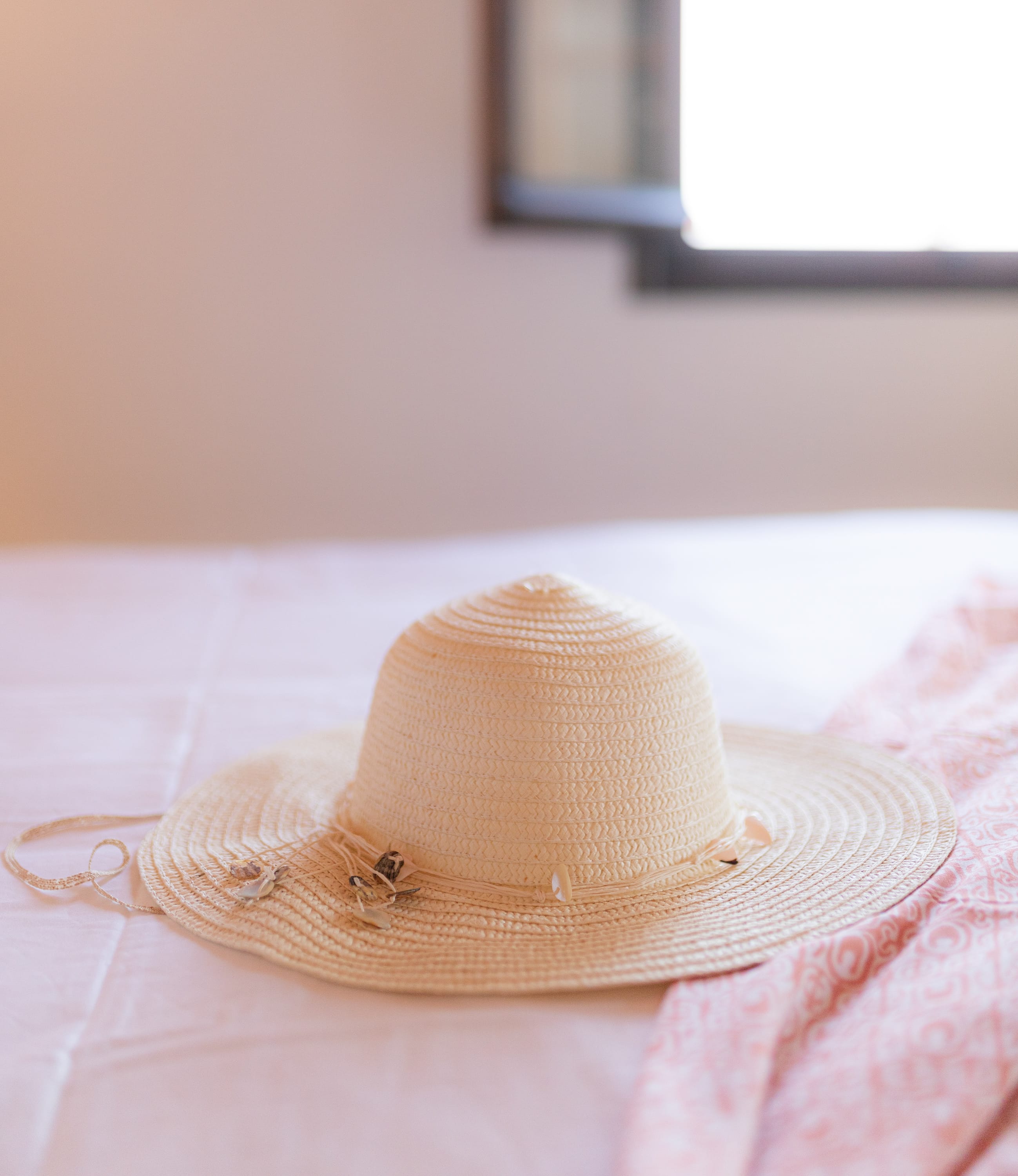 a small tan hat on a bed