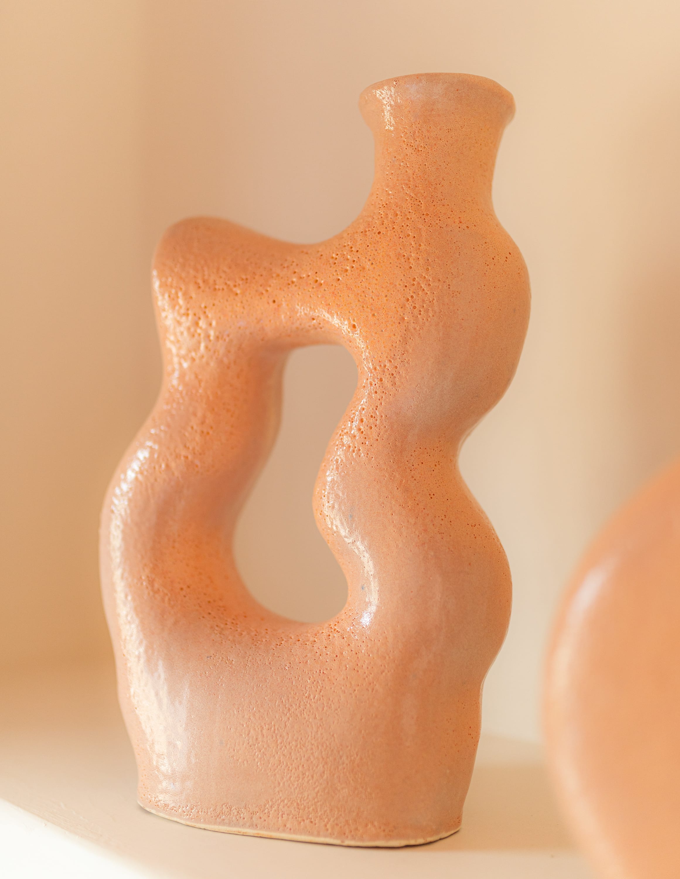 a clay vase on a white surface