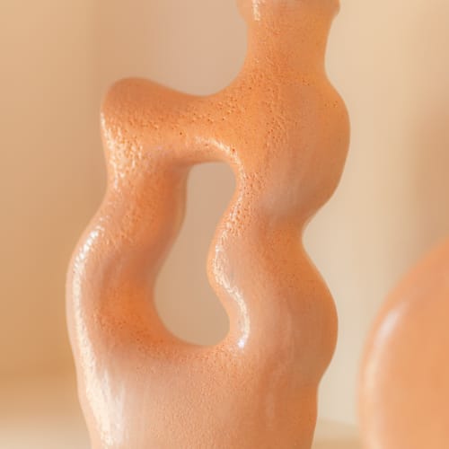 a clay vase on a white surface