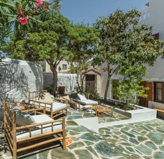a patio with chairs and trees