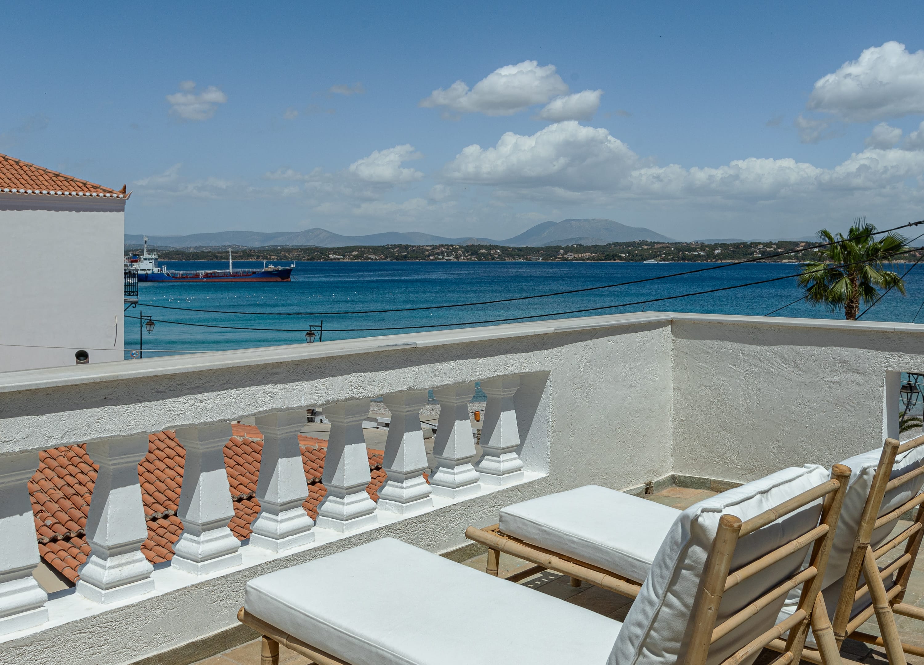 a deck with chairs and tables overlooking a body of water