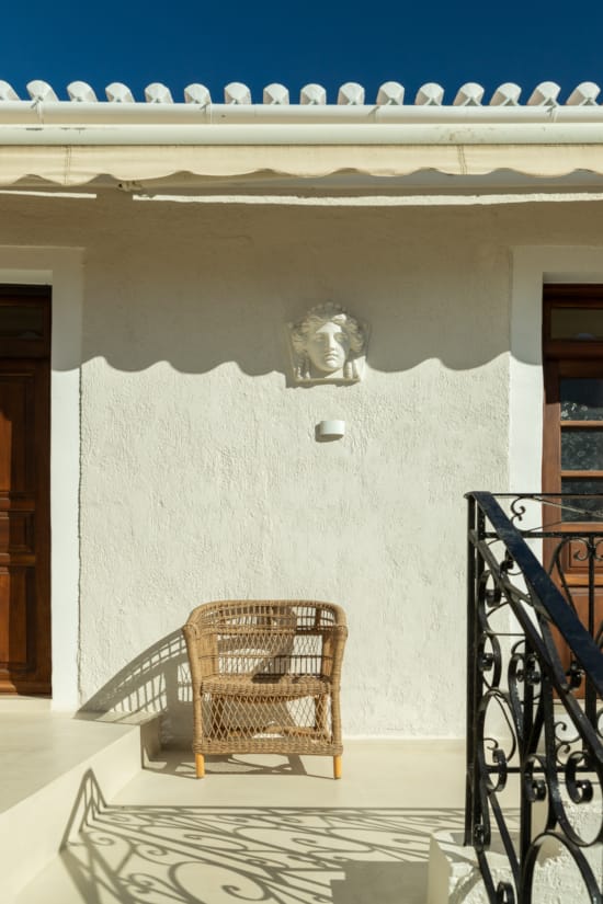 a chair in front of a wall with a statue on it