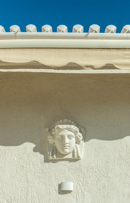 a stone sculpture of a person with a beard and mustache on a white wall