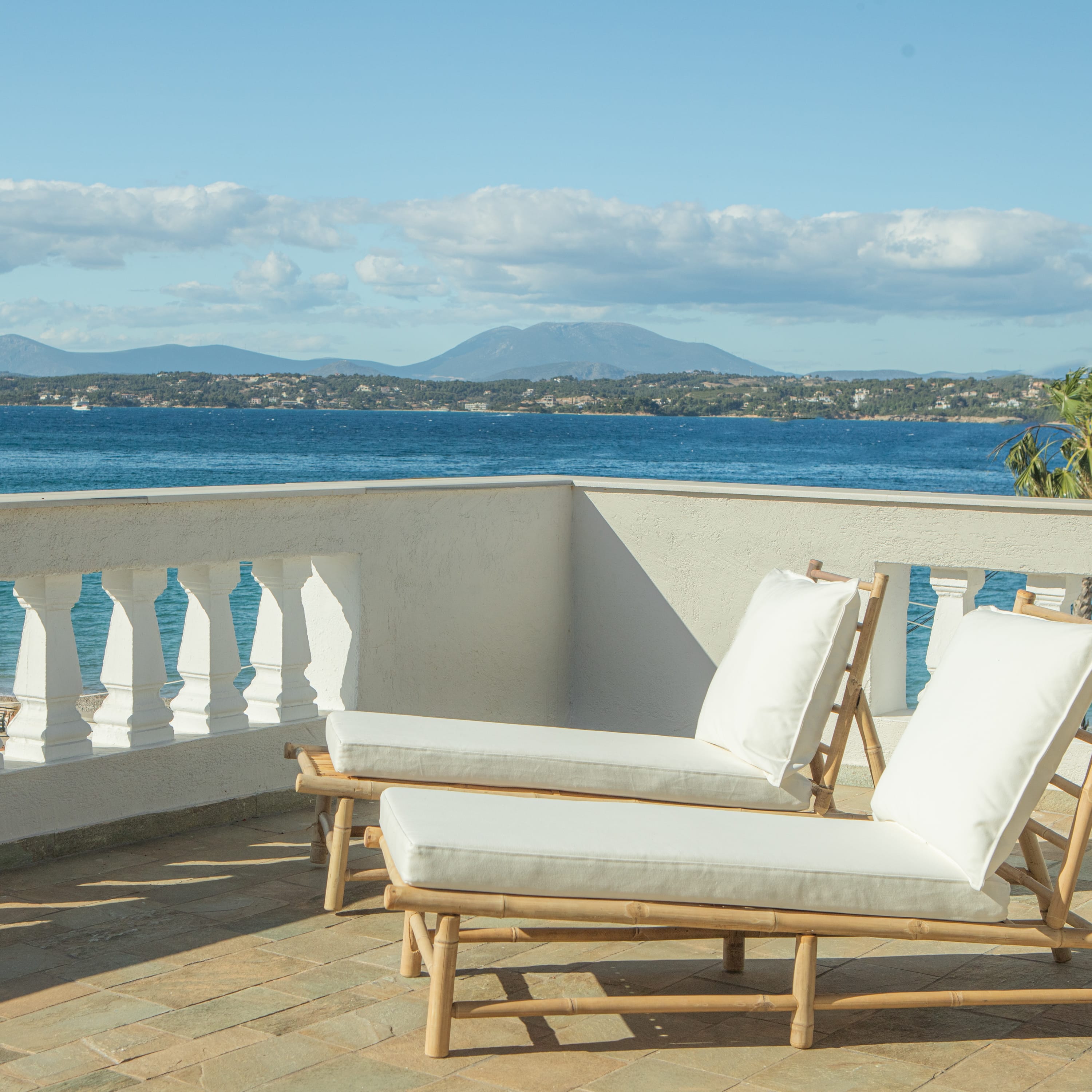 a white lounge chair on a deck overlooking a body of water