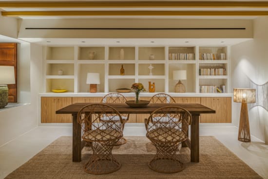 a dining room table with a bookcase and a chair