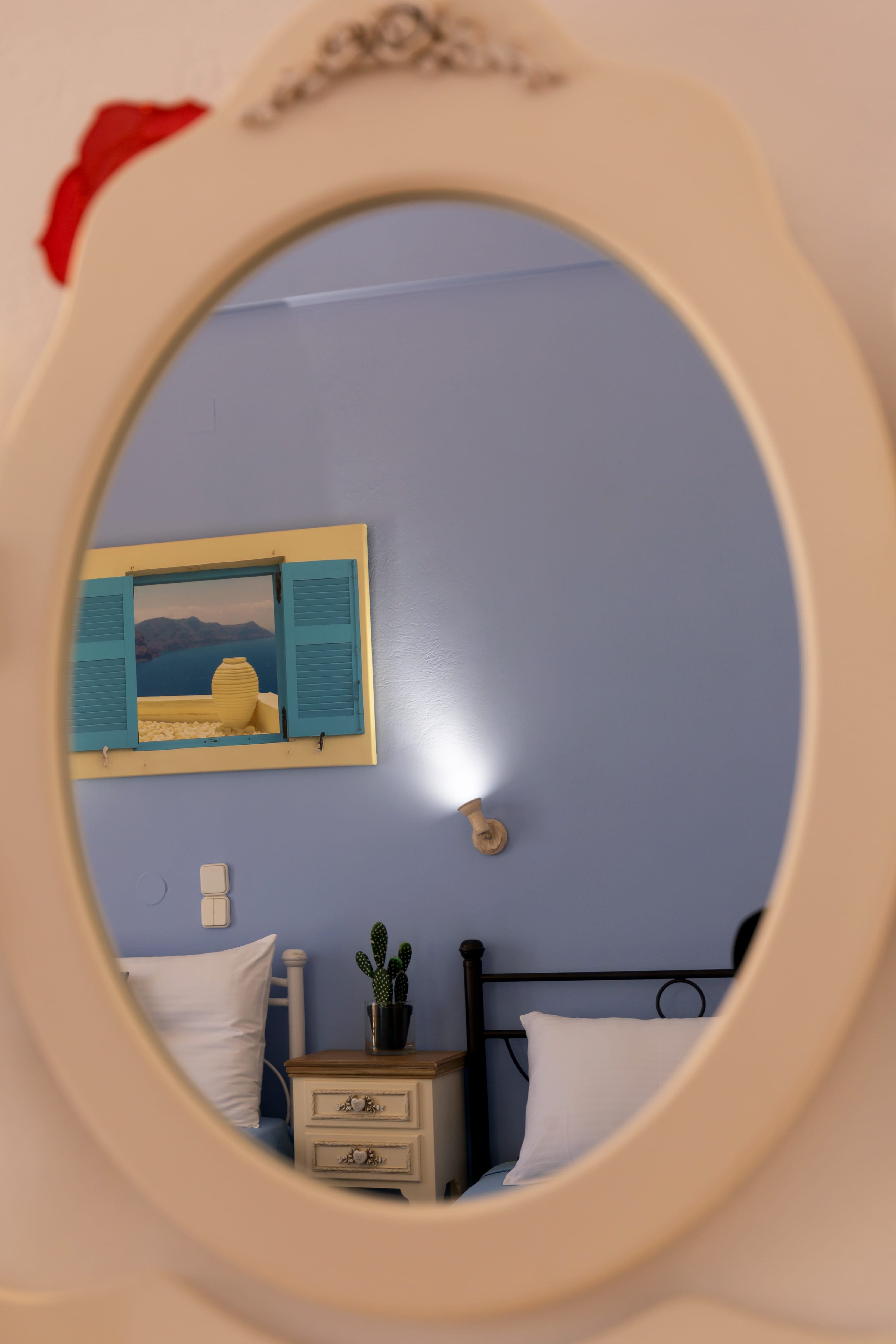 a mirror with a picture of a bed and a plant